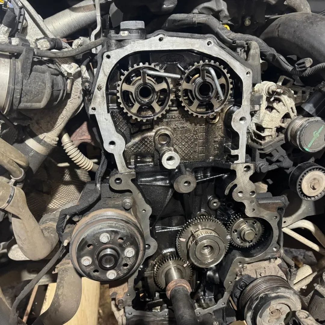 Engine front cover removed showing camshaft gears and timing gear