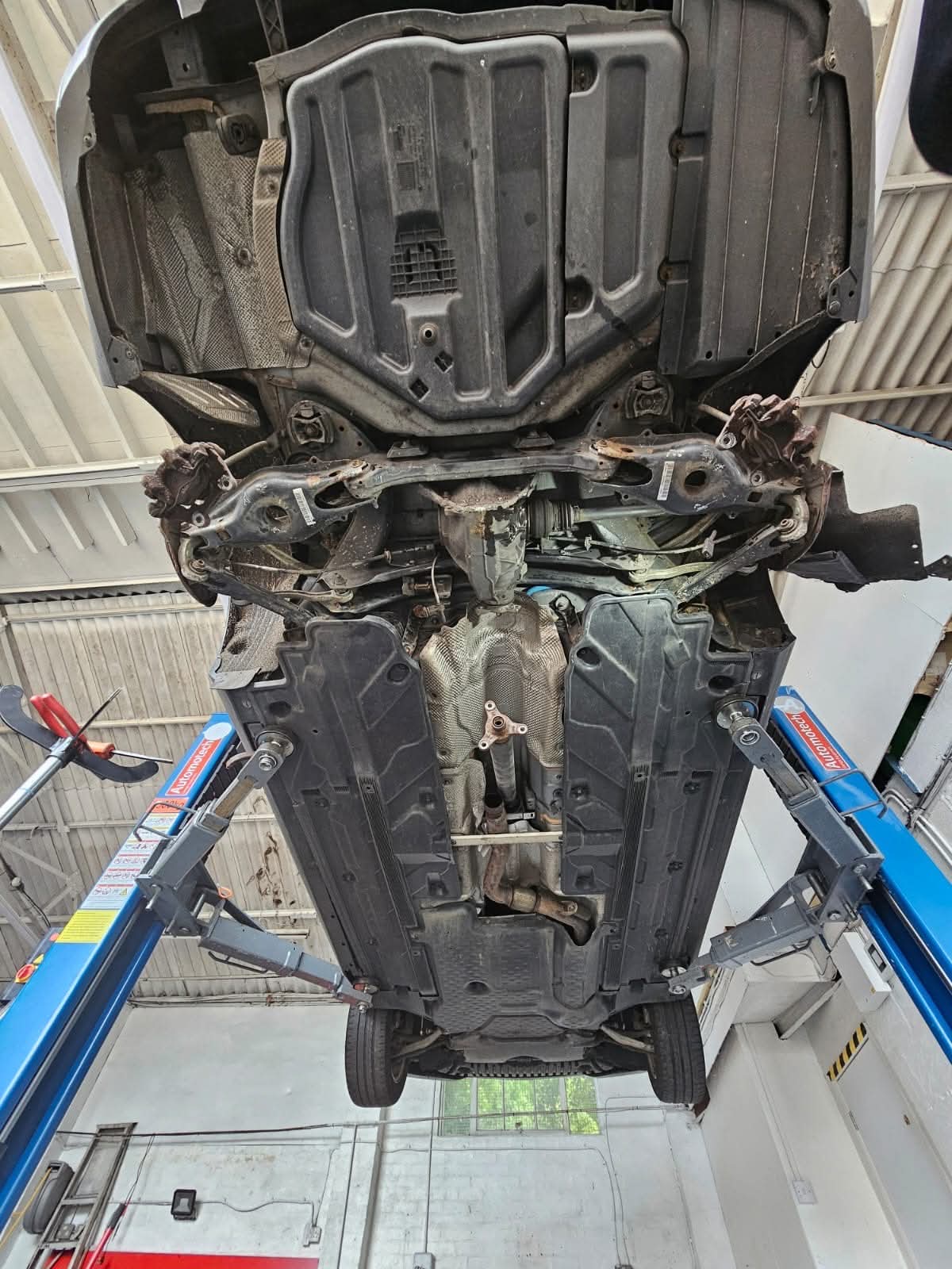 Underside of a car raised on the ramp showing subframe and exhaust